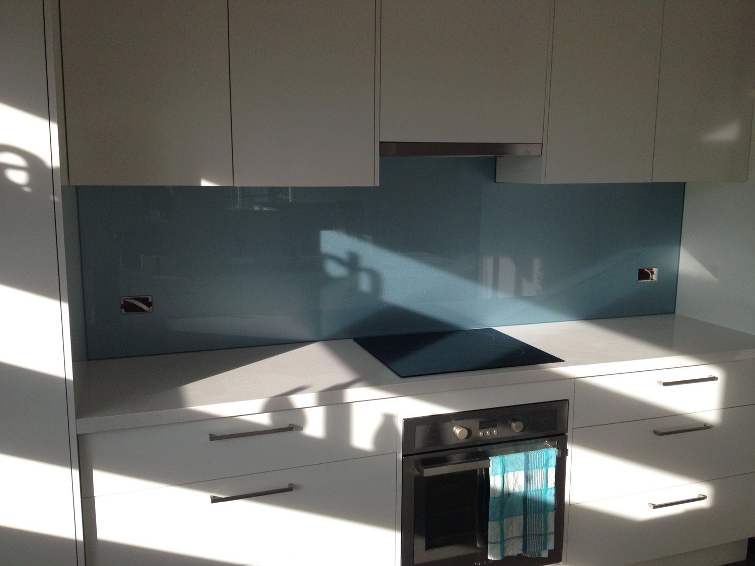 A Kitchen with a Powder Blue Wall and Splashback — Glass Windows & Doors in Shoalhaven, NSW