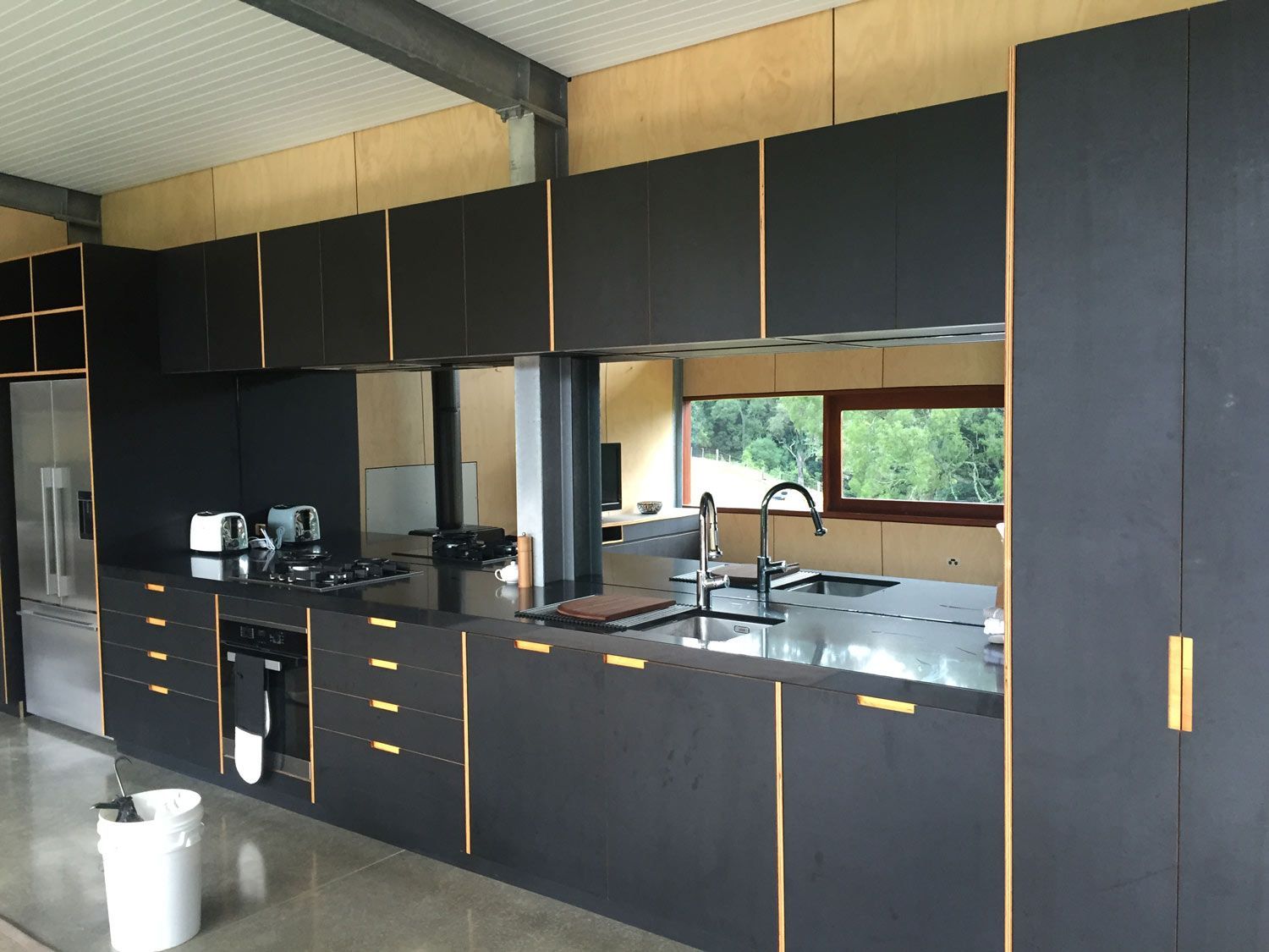 A Black Theme Kitchen with a Mirror Splashback — Glass Windows & Doors in Shoalhaven, NSW