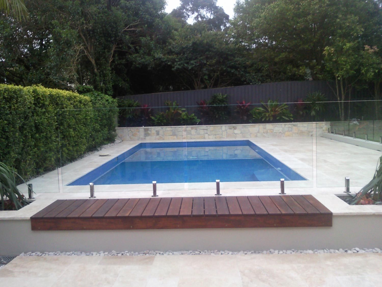 A Pool with Glass Fencing and Wood Deck — Glass Windows & Doors in Shoalhaven, NSW