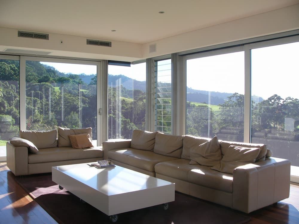 A Living Room Filled With Furniture And Large Windows - Previous Projects in South Nowra, NSW