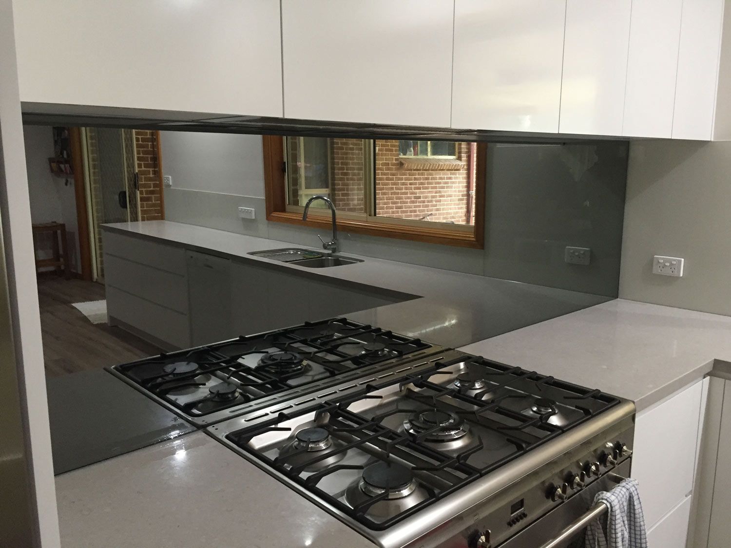 A Kitchen with a Mirror Splashback — Glass Windows & Doors in Shoalhaven, NSW