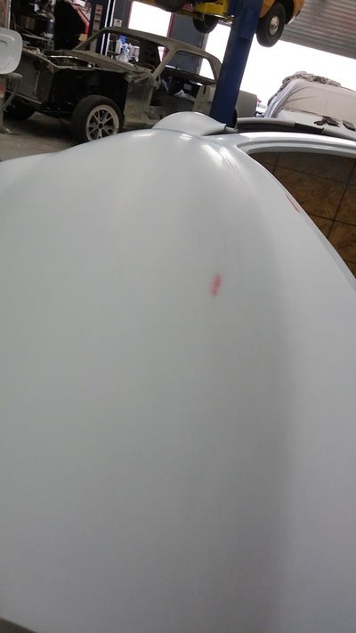 A white car is being built in a garage