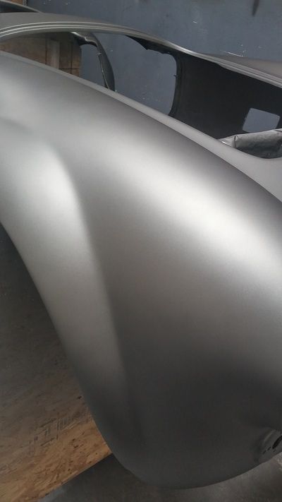 A close up of a car fender on a wooden table.