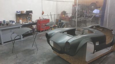 A car is being painted in a garage