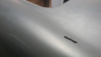 A close up of a metal surface with a hole in it