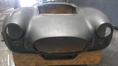 The front end of a car is sitting on top of a wooden box