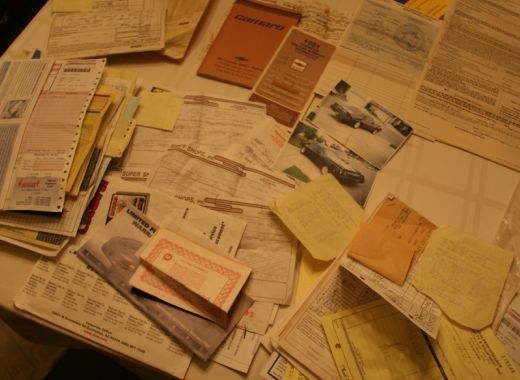 A bunch of papers on a table one of which has the letter g on it