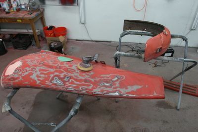 A red piece of metal is sitting on a table in a garage