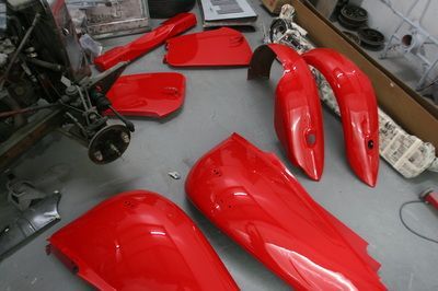 A bunch of red fenders are sitting on the floor