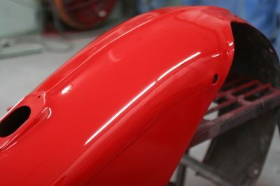 A close up of a red motorcycle fender on a table