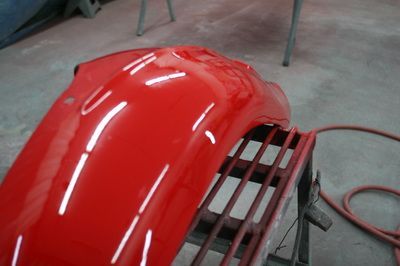 A red fender is sitting on a metal stand