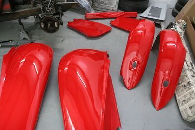 A bunch of red motorcycle parts are sitting on a table