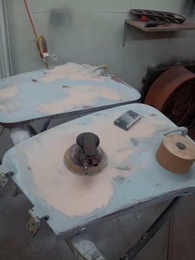 A sander is sitting on a table next to a roll of tape