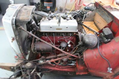 A red and white engine is sitting in a garage