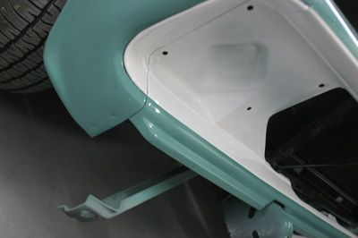 A green and white car is parked in a garage