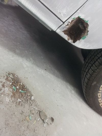 A close up of a car 's side with a hole in it