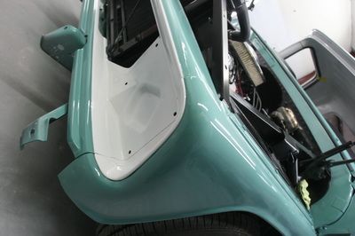 A blue car with the door open is sitting in a garage