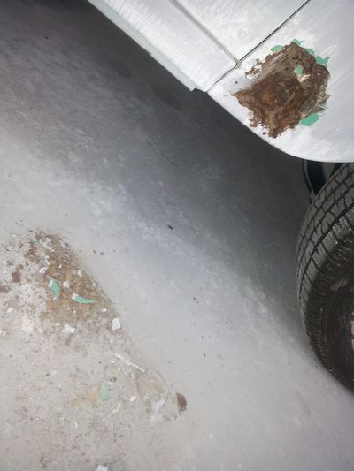 A close up of a car 's fender and tire on a snowy road