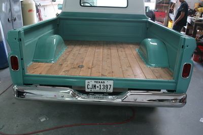 A truck with a texas license plate is parked in a garage