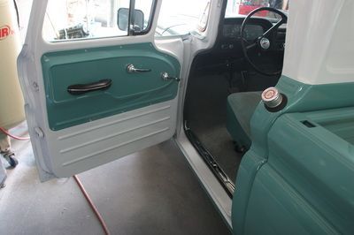 The inside of a white and green truck with the door open