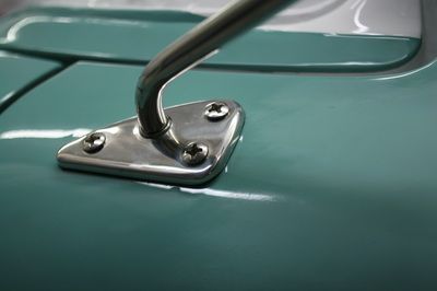 A close up of a rear view mirror on a green car