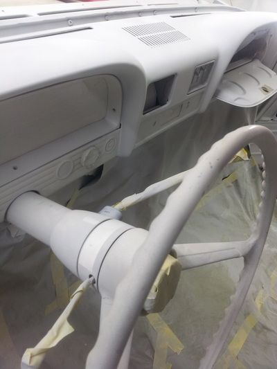 A white steering wheel is sitting on top of a white dashboard