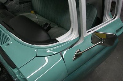 A blue car with a mirror on the side of it