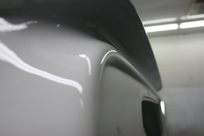 A close up of a white car with a spoiler on it