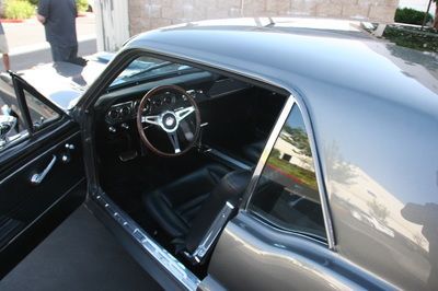 A black car with the door open and a steering wheel