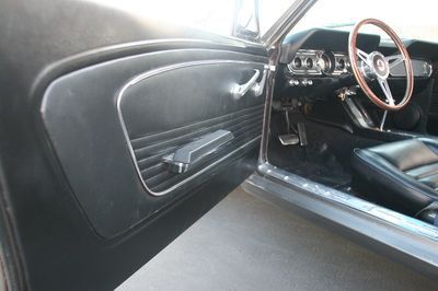 The inside of a car with the door open and a steering wheel