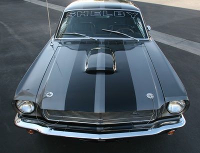 A black shelby mustang is parked on the side of the road