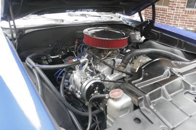 The engine of a blue car with the hood open