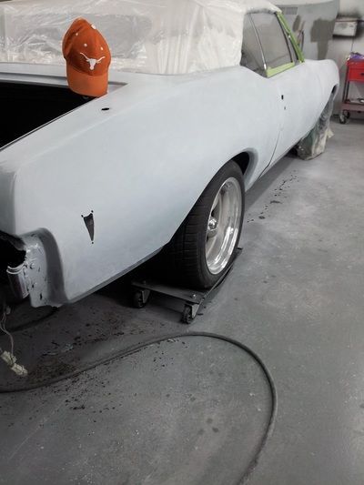 A white car is sitting on a dolly in a garage