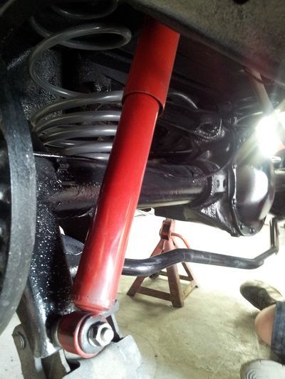 A close up of a red shock absorber on a car