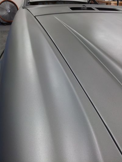 A close up of the hood of a silver car