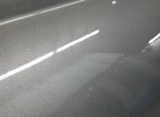 A close up of a gray car with a white line on it