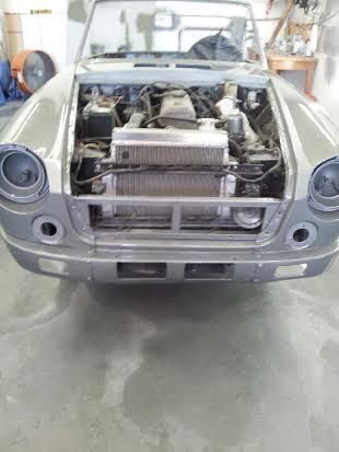 A car with the hood open is sitting in a garage