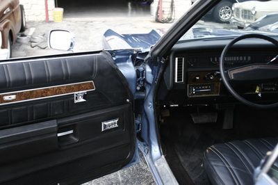 The inside of a car with the door open and the steering wheel visible