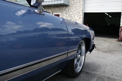 A blue car is parked in front of a garage door