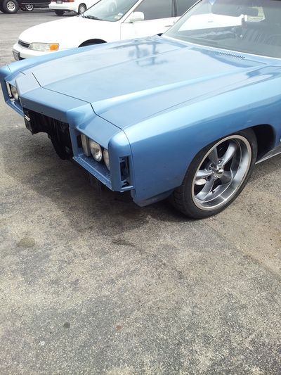 A blue car is parked next to a white car