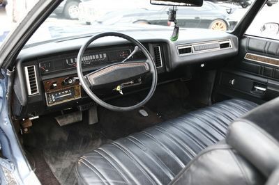 The interior of a blue car with black seats and a steering wheel