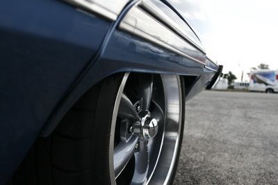 A close up of a car 's wheel in a parking lot