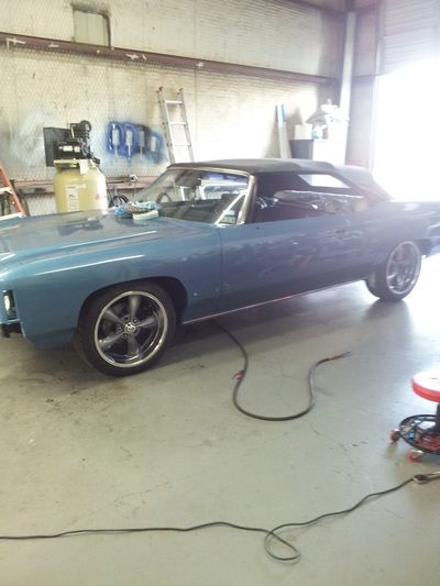 A blue car is parked in a garage