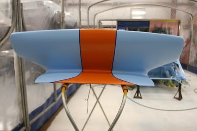 A blue and orange chair is sitting on a stand