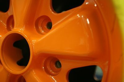A close up of an orange wheel with a hole in the middle