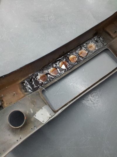 A piece of metal with holes in it is sitting on a table