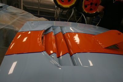 A close up of the hood of a car with orange stripes