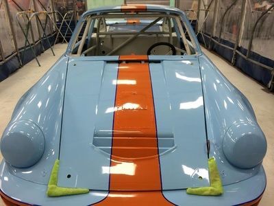 A blue and orange race car is sitting in a garage