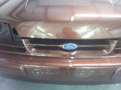 A brown ford mustang is parked in a garage
