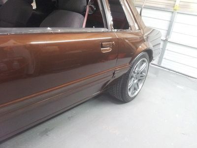 A brown car is parked in a garage next to a garage door